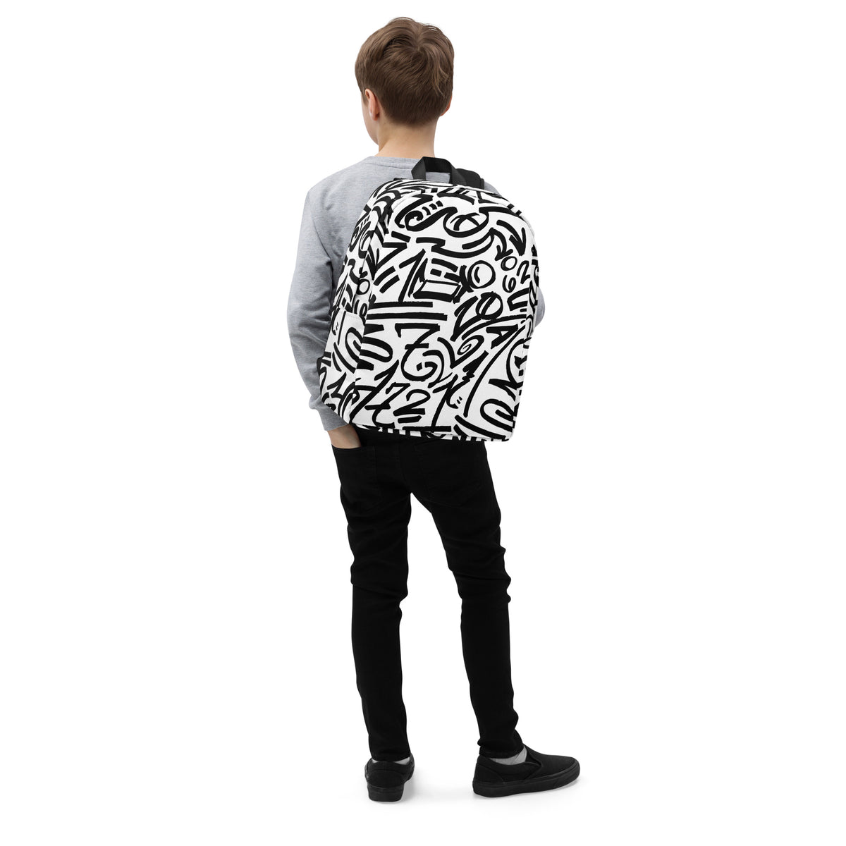 Child seen from behind wearing the black-and-white glyph backpack over a grey sweatshirt