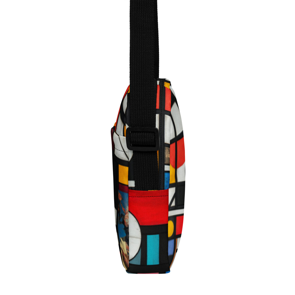 Left edge of the crossbody bag, black webbing strap over red, teal and yellow blocks